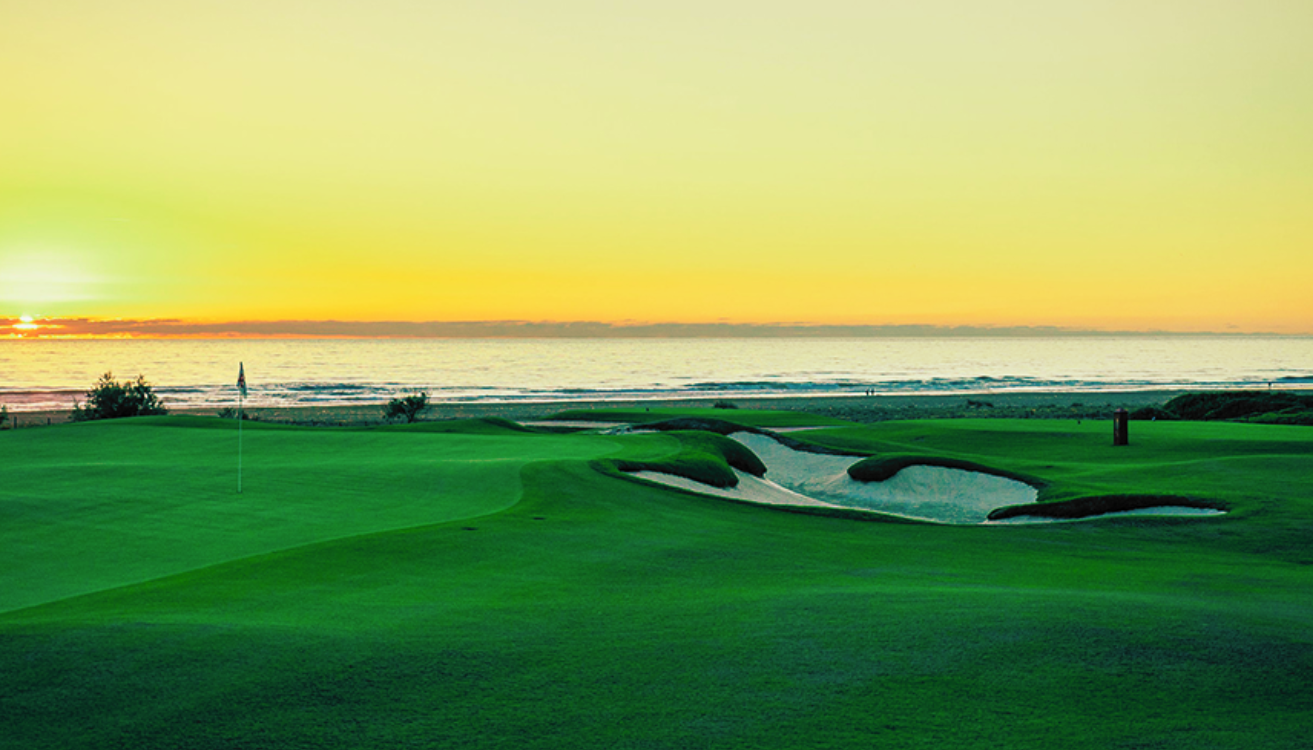 Fairway and bunkers facing the ocean at sunset