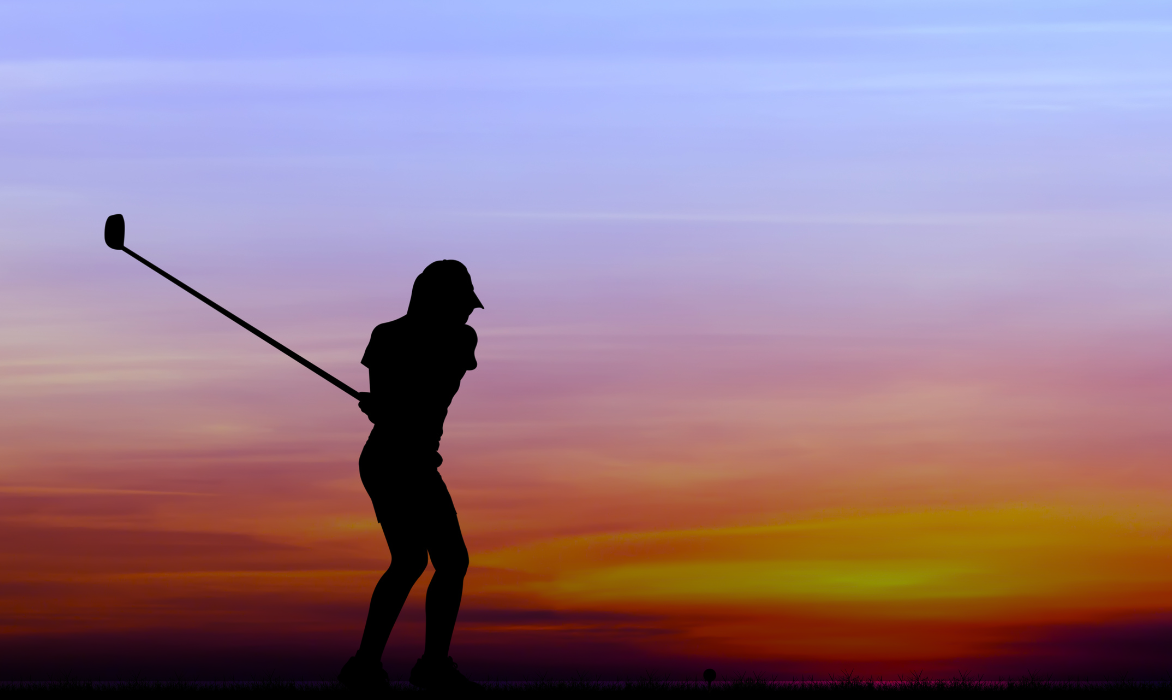 Silhouette of a woman golfer at sunset