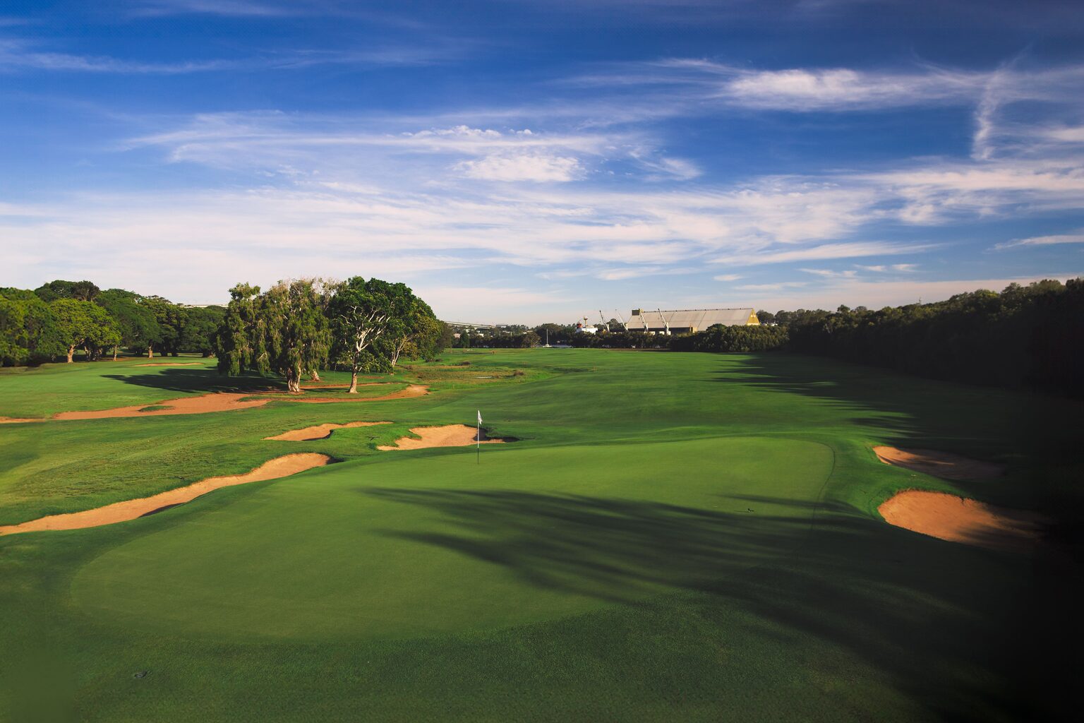 Vue aérienne d'un parcours de golf, fairways verts découpés entre les arbres