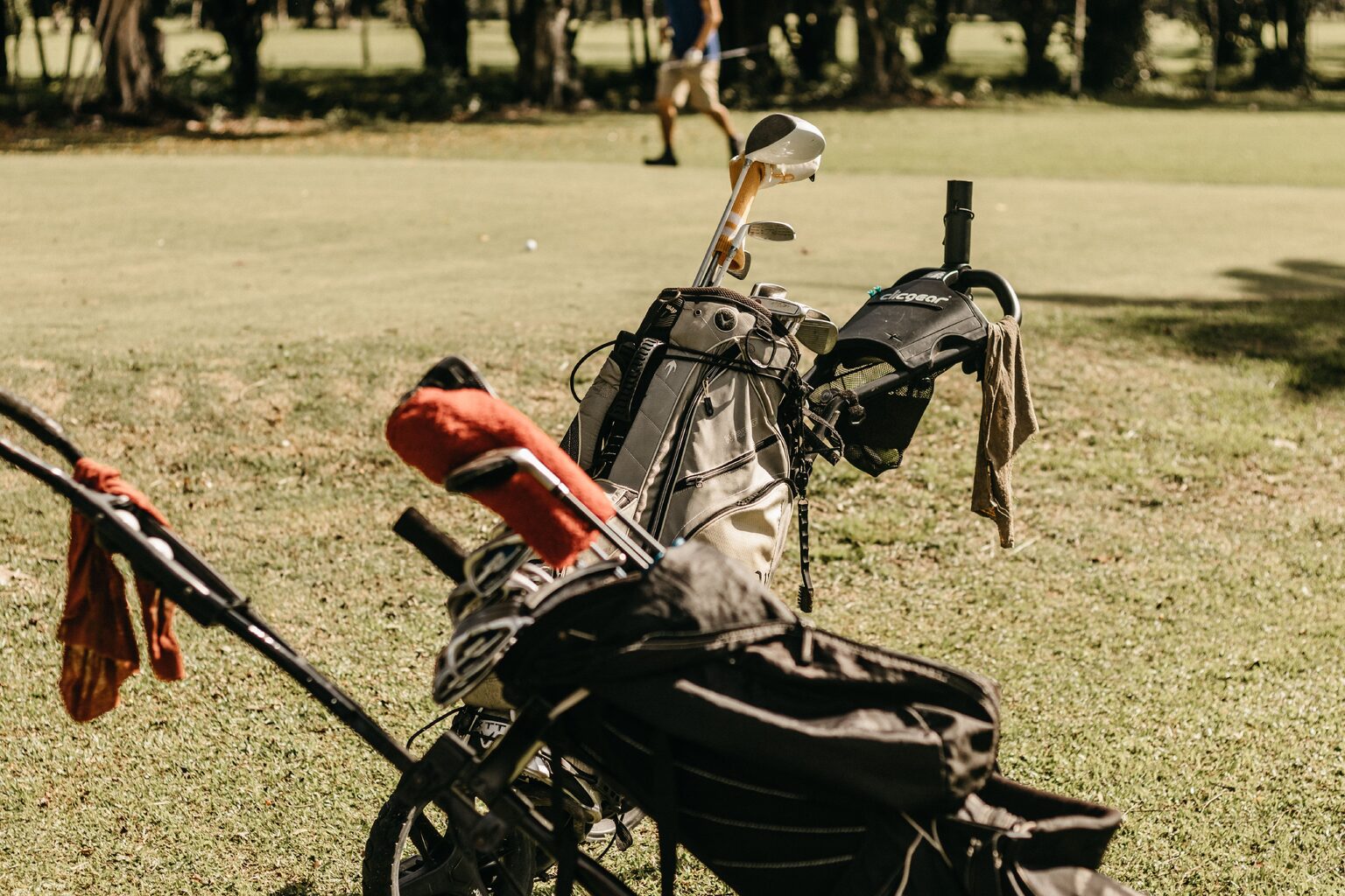 Sac de golf et série de clubs posés au bord d'un fairway ensoleillé